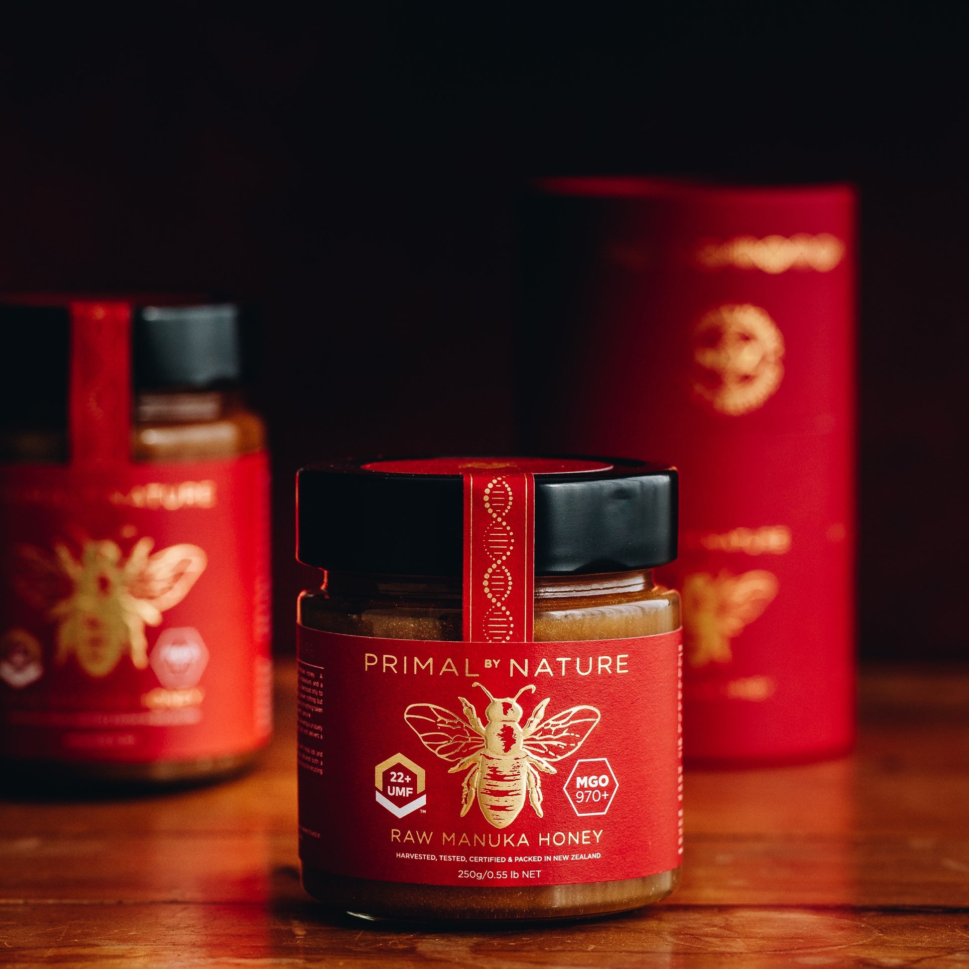 Primal by Nature Glass Jar Genuine 100% Pure Manuka Honey UMF 22+ MGO 970 Jar in the foreground with larger jar and packaging tube in the background
